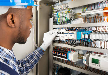 Electrical technician inspecting a control system